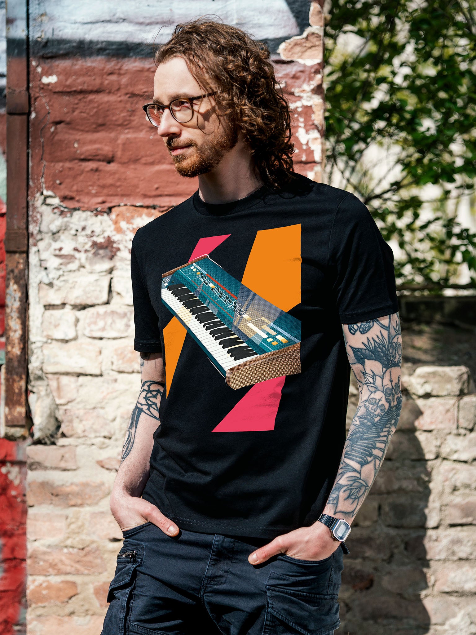 Black T-shirt with a graphic design of a colorful synthesizer with pink and orange geometric colorful elements.