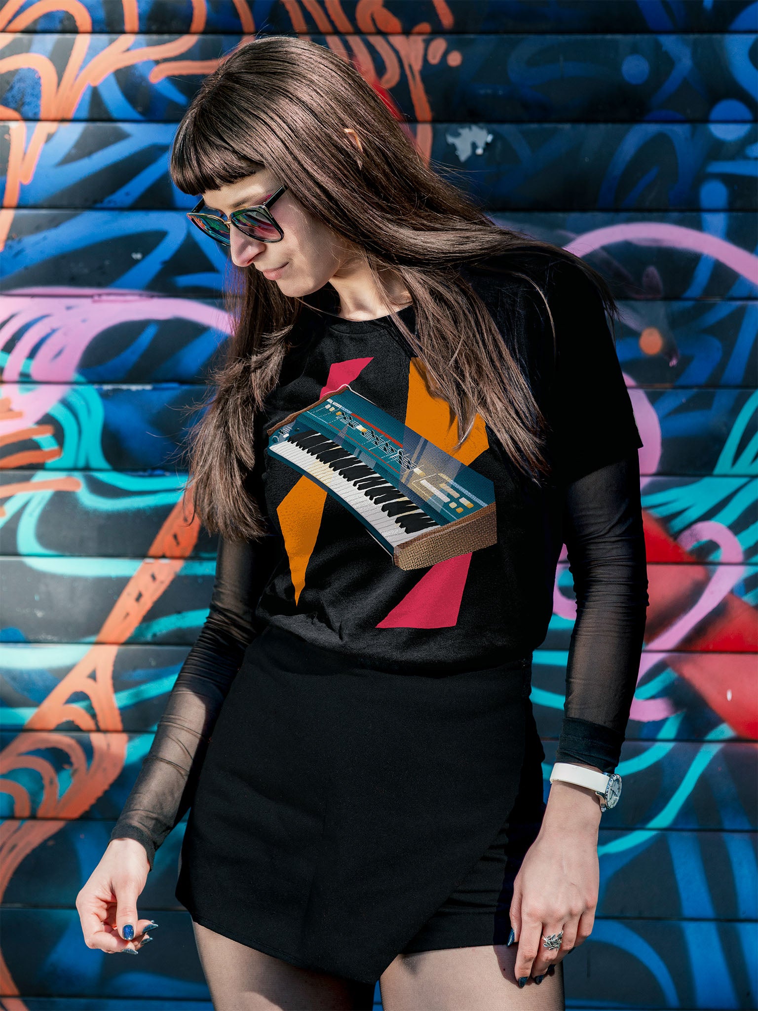 Black T-shirt with a graphic design of a colorful synthesizer with pink and orange geometric colorful elements.