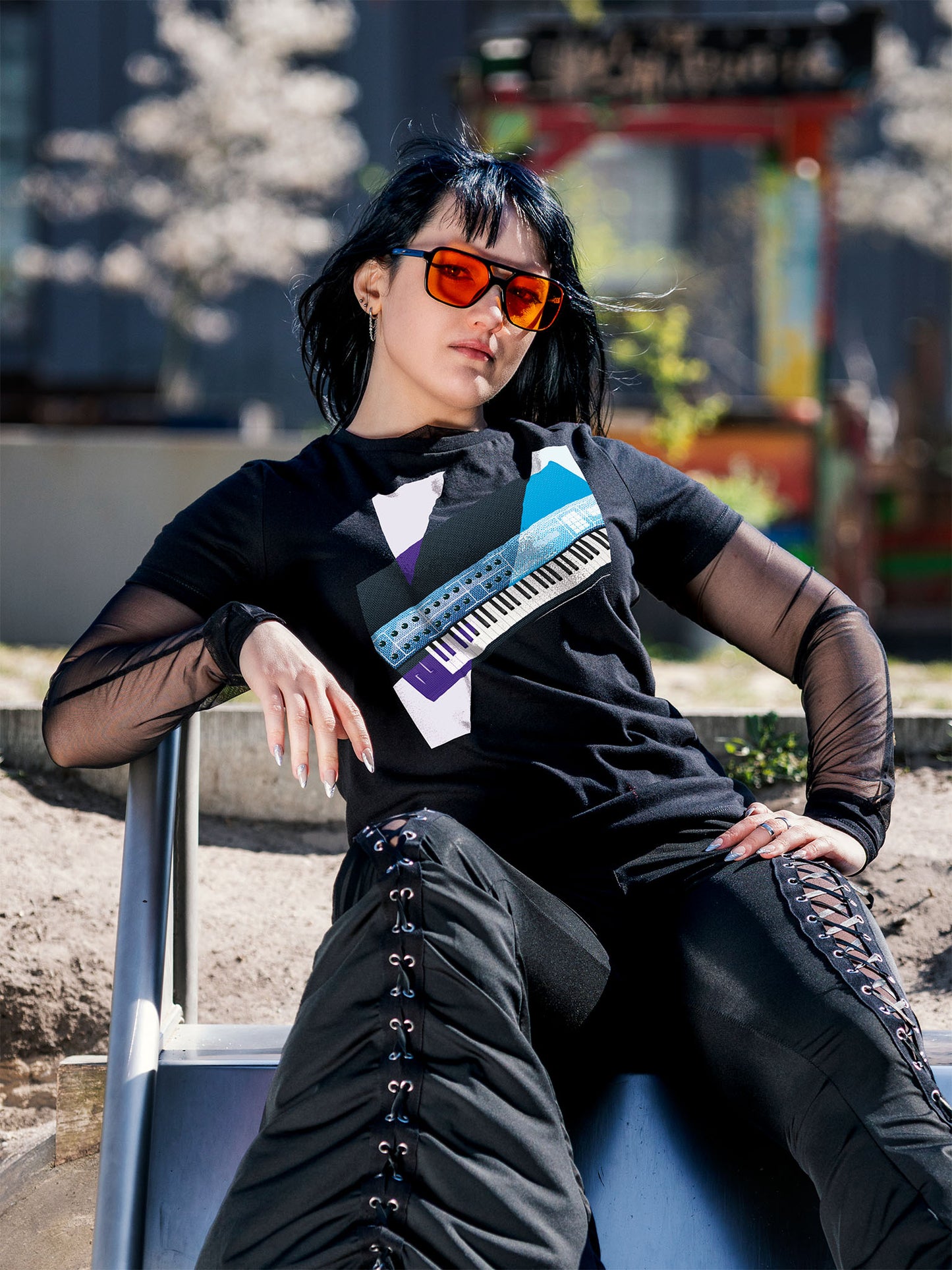 Black T-shirt with a graphic design of a colorful synthesizer with white and purple geometric colorful elements.